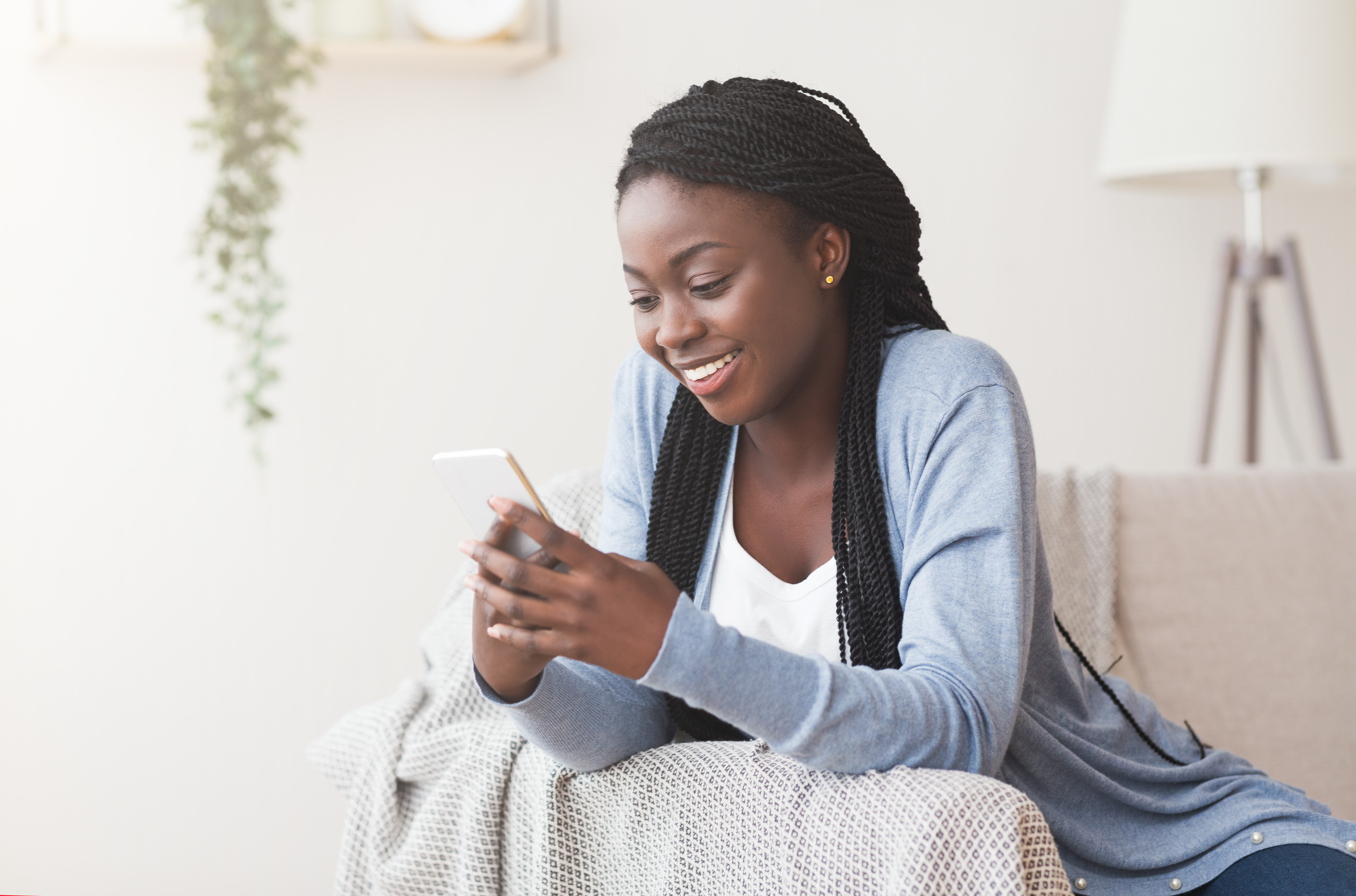 With online training, caregivers are able to learn in their preferred language and on their own time. Image Description: Woman smiling at her phone.